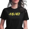 A woman wearing black Trump 2024 45/47 MAGA Re-election unisex T-Shirt - Patriotic political merch on female model